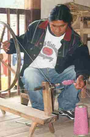Man sitting at a spinning wheel
