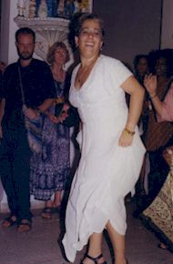 A woman in a white dress dancing and smiling