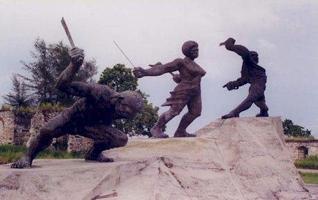 Three bronze statues breaking their bonds