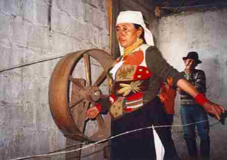 A woman with a large spinning wheel
